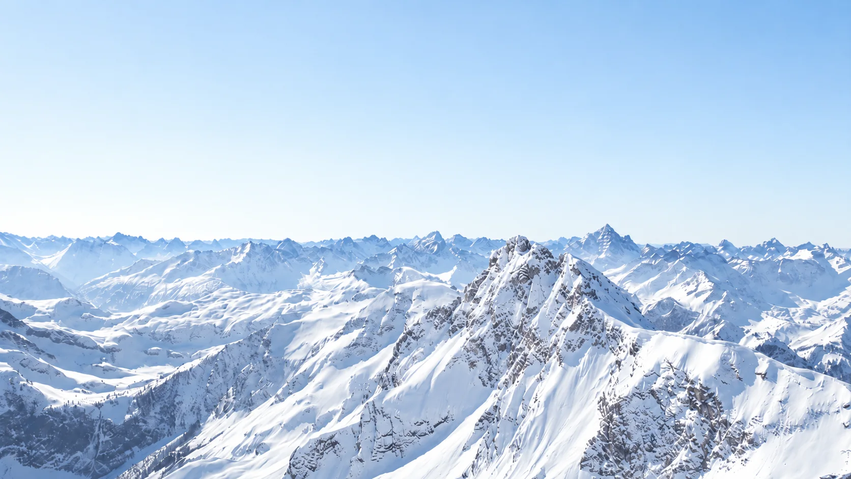 Verschneite Bündner Berggipfel unter klarem Himmel