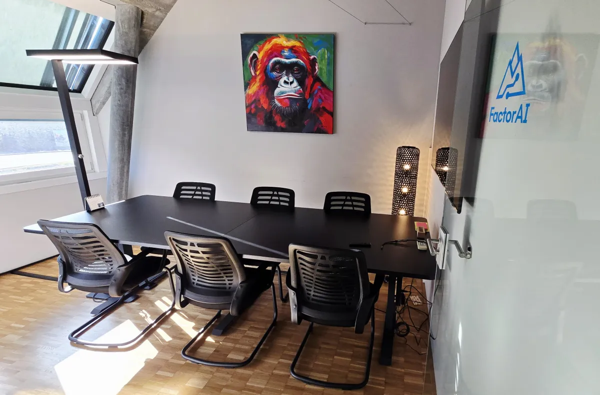 Sitzungszimmer mit langem Tisch und farbigem Affenbild
