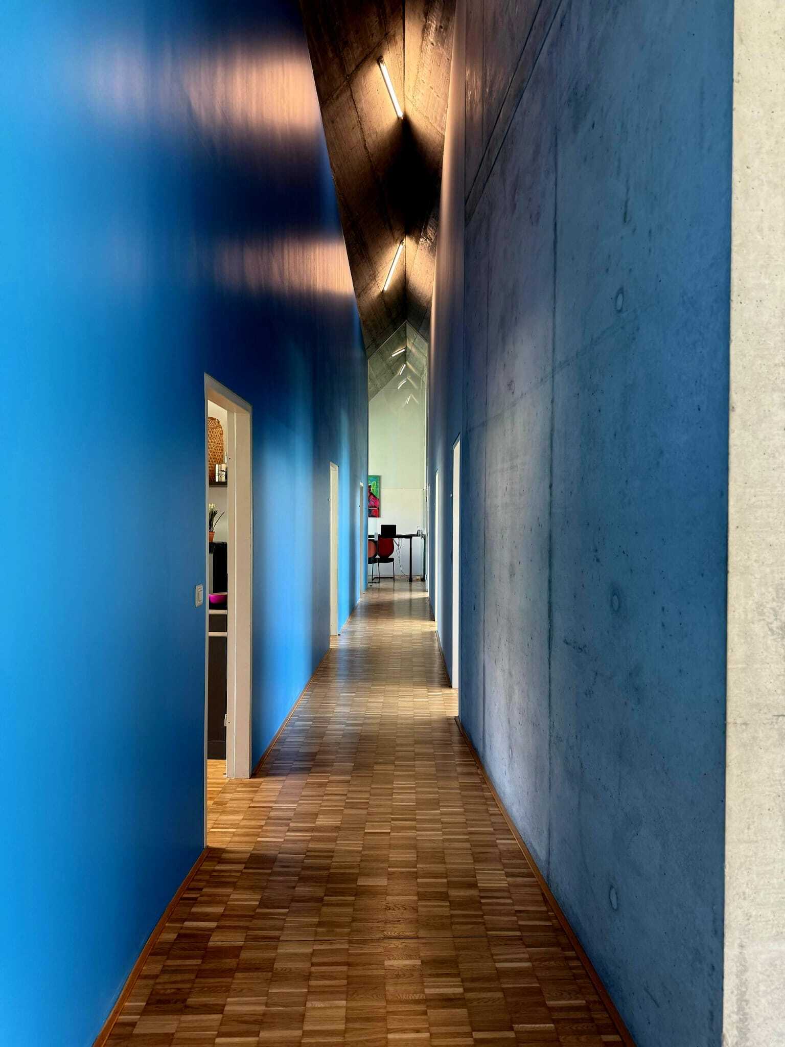 FactorAI Korridor mit blauer Wand und Sichtbeton
